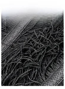 Close-up of black woven material texture with fringe details and wide strap craftsmanship