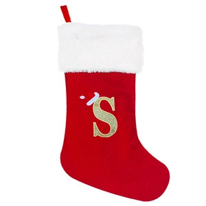 Detailed view of red velvet Christmas stocking with gold glitter letter S and faux fur trim