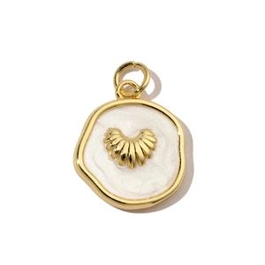 Macro shot of gold-plated seashell pendant with pearl white enamel and metal details