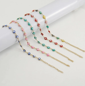 Detail of five evil eye bracelets with colorful enamel on 18K gold-plated steel chains