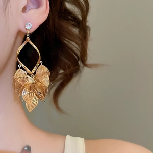 Macro shot of long gold leaf tassel earrings with sparkling clear cubic zirconia accents