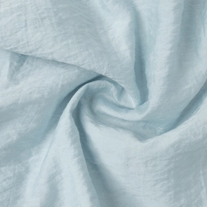 Detailed macro view of light blue ruffled fabric with elegant texture and soft silk sheen