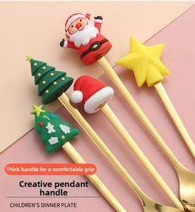 Detail of five golden stainless steel spoons with festive silicone Christmas character tops