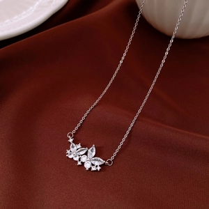 Macro della collana a fiori placcata oro 18K argento su uno sfondo di velluto rosso