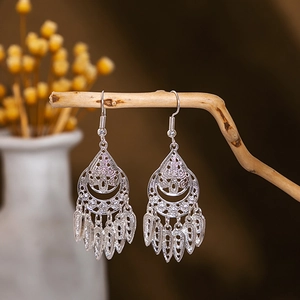 Detailed close-up of bohemian hollow silver earrings with water drop tassel fringe