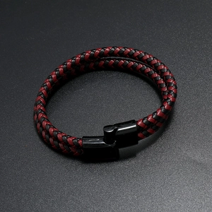 Dettaglio del bracciale in pelle intrecciata rossa e nera con chiusura magnetica nera