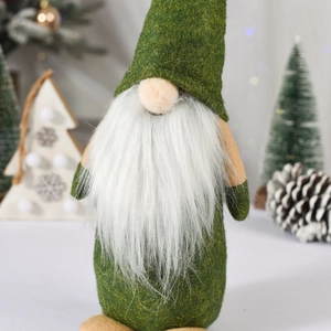 Close-up of green felt Christmas gnome with white faux fur beard and soft plush nose