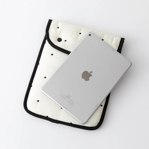 Detailed view of white quilted tablet sleeve with black polka dots and protective edges