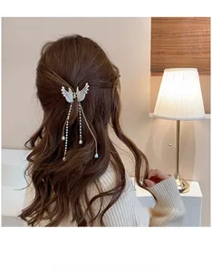 Detail view of butterfly hair claw with pearls and long tassel chains on hair