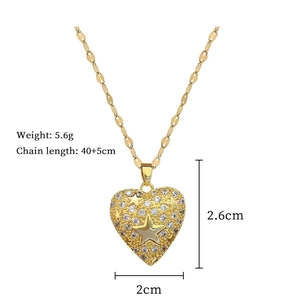 Macro shot of gold heart pendant with star engraving and dimensions 2.6cm by 2cm