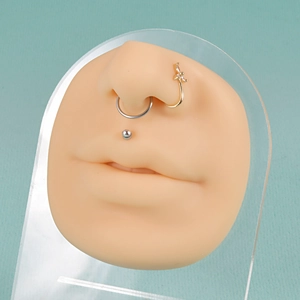 Silicone nose and mouth piercing model with silver and gold jewelry and cubic zirconia