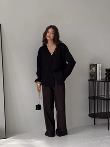 Vue complète d'un cardigan noir à col en V avec pantalon large marron et sac à main chic