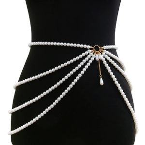 Detail of multi-layer white faux pearl waist chain with golden ring and teardrop pendants