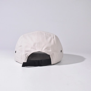 Detail of adjustable black nylon strap and clip on a neutral outdoor 5-panel canvas cap