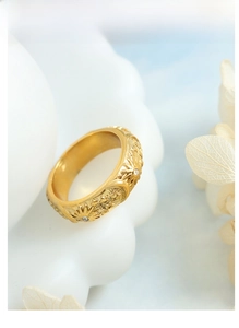 Detail of vintage 18K gold plated ring with celestial sun and moon relief patterns