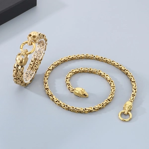 Close-up of gold Byzantine chain necklace and bracelet with skull head connectors