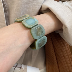 Detailed macro view of resin square beaded bracelet with green-brown marble texture