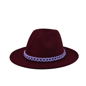 Close-up of a burgundy wide brim wool fedora hat featuring a purple chain link decoration