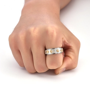 Close-up of rotatable celestial ring with sun, moon, and stars on a hand model