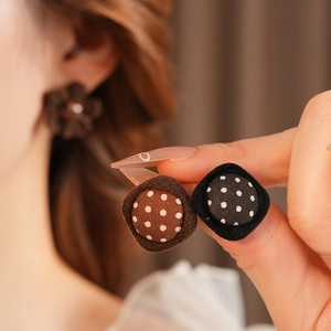 Detail shot of brown and black polka dot fabric button earrings with silver needles