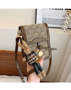 Detailed shot of canvas phone bag with bear patterns and cute rabbit doll keychain