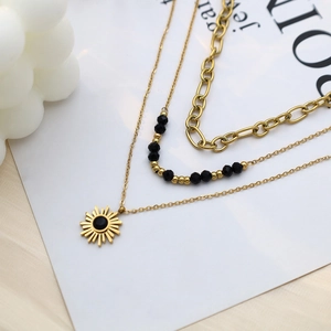 Three-layer gold layered necklace with black beads and a sunburst pendant for women