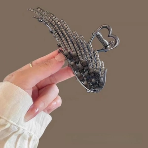 Detailed view of silver angel wing hair claw clip with cat eye stones and grey rhinestones