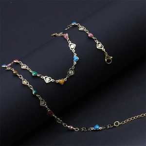 Close-up of golden heart link bracelet with colorful glitter accents and lobster clasp