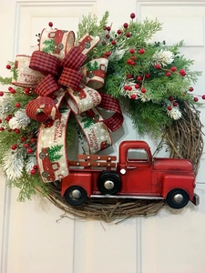 Detail of Christmas wreath with red truck, plaid bow, and Merry Christmas ribbon decoration