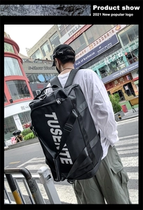 Outdoor view of a black oxford backpack with white TUSENITE logo worn by a model