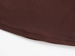 Detailed macro view of the double-needle stitching on the dark brown t-shirt hemline
