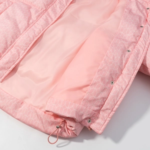 Detail der rosa wattierten Jacke mit weißen geometrischen Mustern und Metalldruckknöpfen