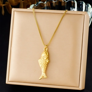 Macro detail of gold fish pendant with scale texture on premium jewelry display stand