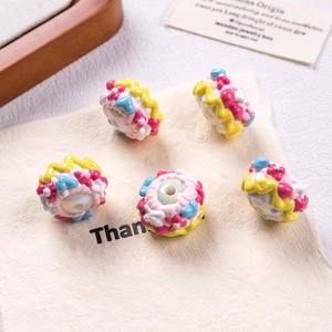Detailed close-up of hand-painted donut-shaped acrylic beads with floral and heart patterns