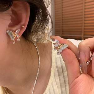 Vue détaillée des boucles d'oreilles papillon avec pierres vert clair et cristaux brillants