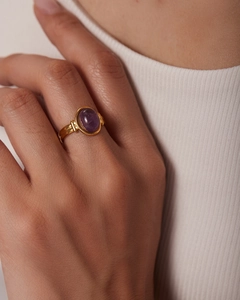 Dettaglio di un anello vintage in oro 18 carati con gemma viola ovale e rilievo