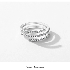 Macro detail of triple-layered sterling silver spiral ring with shimmering pave zircons