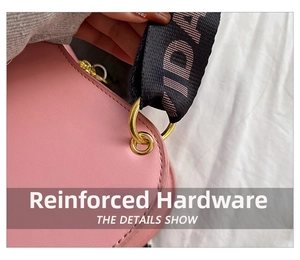 Macro shot of pink leather bag featuring golden metal hardware and guitar strap detail
