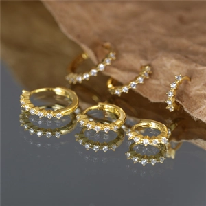 Detailed view of S925 sterling silver gold plated huggie earrings with pavé set crystals