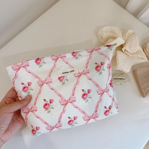 Détail de la trousse de maquillage florale avec ruban rose et étiquette simple wish
