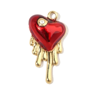 Macro detail of red heart pendant with gold drip effect and sparkling rhinestone inlay