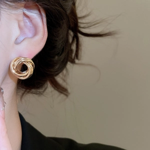 Gros plan de boucles d'oreilles pendantes dorées à cercles creux sur le mannequin