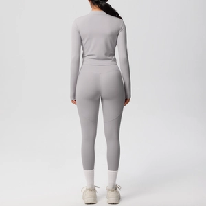 Vue arrière d'un ensemble de yoga gris avec veste ajustée et legging taille haute