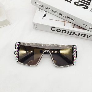 Gros plan sur lunettes de soleil oversize avec strass colorés et verres dégradés noirs