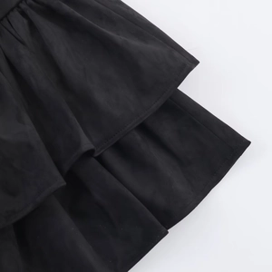 Gros plan détaillé des coutures superposées et texture daim mat sur jupe noire