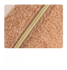 Close-up of golden metal zipper and soft khaki teddy fleece quilted fabric texture