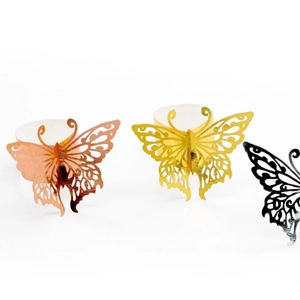 Three shiny butterfly napkin rings in gold, rose gold and dark grey with laser-cut design