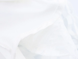 Détail de l'ourlet d'une jupe en dentelle blanche avec coutures et doublure en tulle