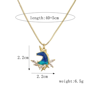 Close-up of golden unicorn necklace pendant showing 2.2cm dimensions and blue star glitter