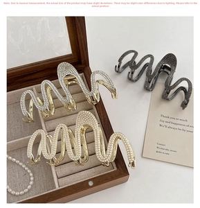 Detailed close-up of large wave hair claws with rhinestones and pearls in assorted colors